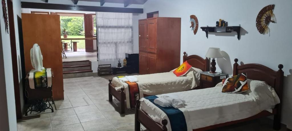 a bedroom with two beds and a room with a window at Casa MOVA in San Lorenzo