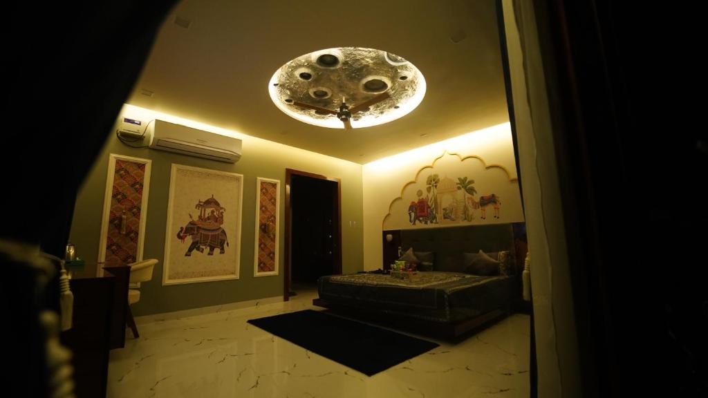 Habitación con cama y lámpara de araña. en PANORAMIC PARADISE, en Alwar