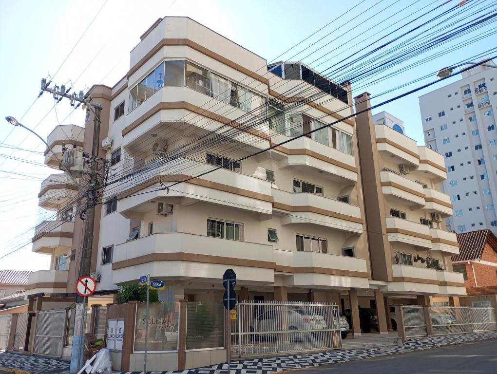 a building on the corner of a street at Linda Cobertura duplex compartilhada a duas quadras do mar in Itapema