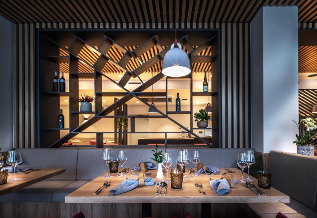 فندق تانينبيرغ في سالباخ هينترغليم: غرفة طعام مع طاولة مع كؤوس للنبيذ
