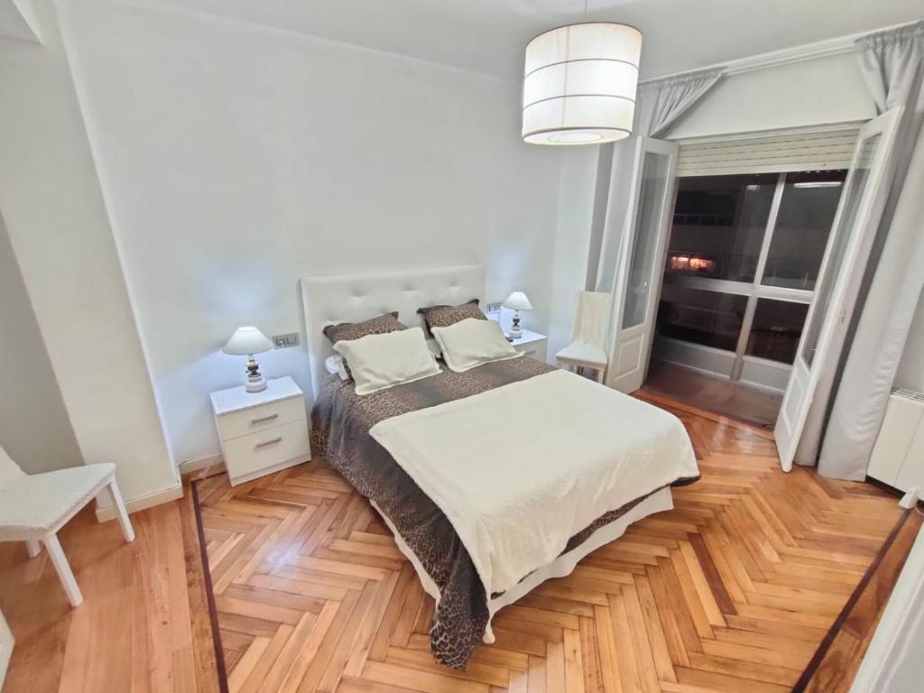 a bedroom with a large bed and a wooden floor at Vintage House in Vigo