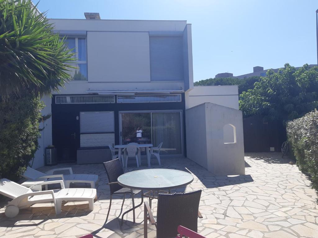 un patio avec une table et des chaises devant une maison dans l'établissement Villa n°1, à Canet