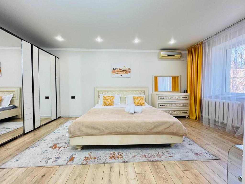 a bedroom with a large bed and a mirror at Infinity Estate MEGA Park in Almaty