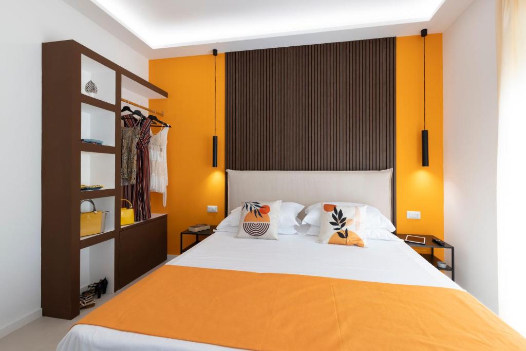1 dormitorio con 1 cama con pared de color naranja en Citrus Home, en Meta