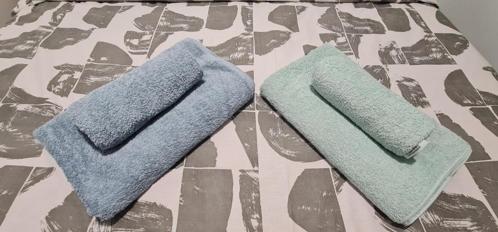 duas toalhas sentadas em cima de uma cama em ΑΘΗΝΑ A7 em Kateríni