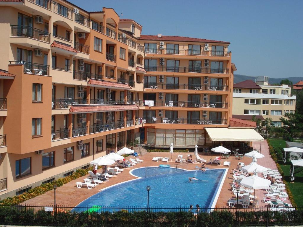 a hotel with a swimming pool in front of a building at Apart Hotel Happy in Sunny Beach