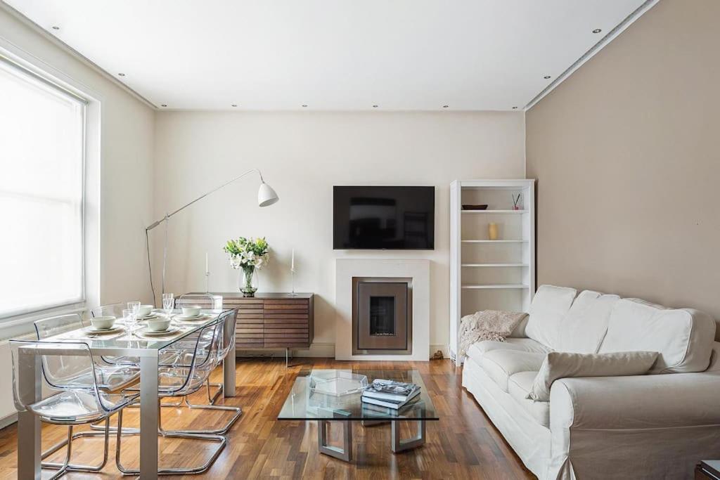 sala de estar con sofá blanco y mesa en The Sophisticated Apartment in Knightsbridge en Londres