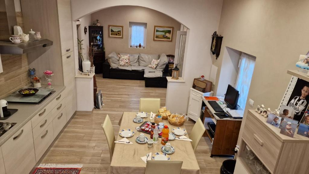 a kitchen with a table and a living room with a couch at La Casa di Mimmo in Gradara