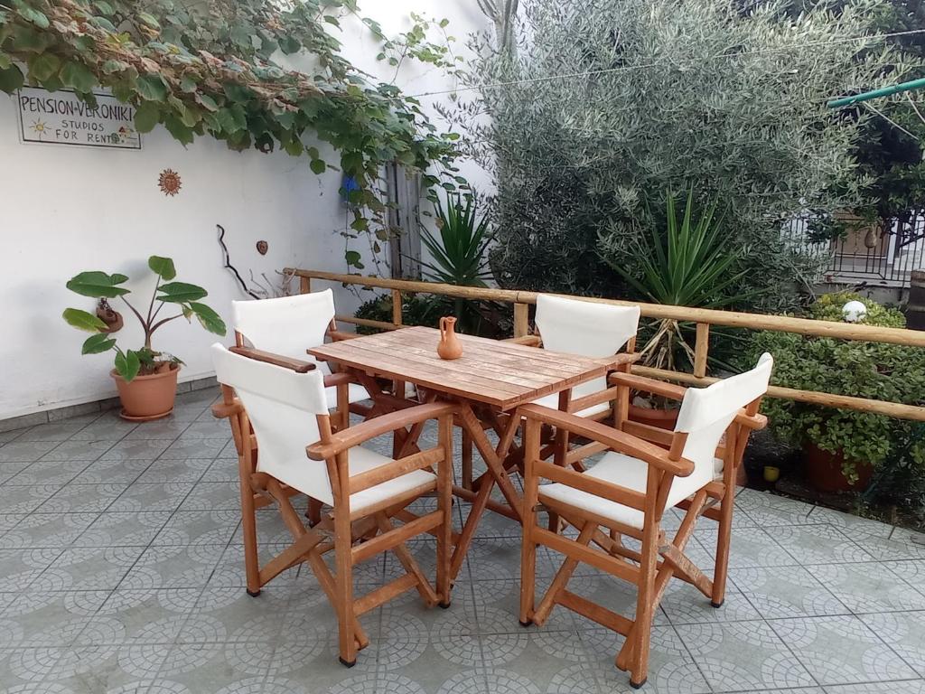 a wooden table and chairs on a patio at Veroniki Studios in Kokkari