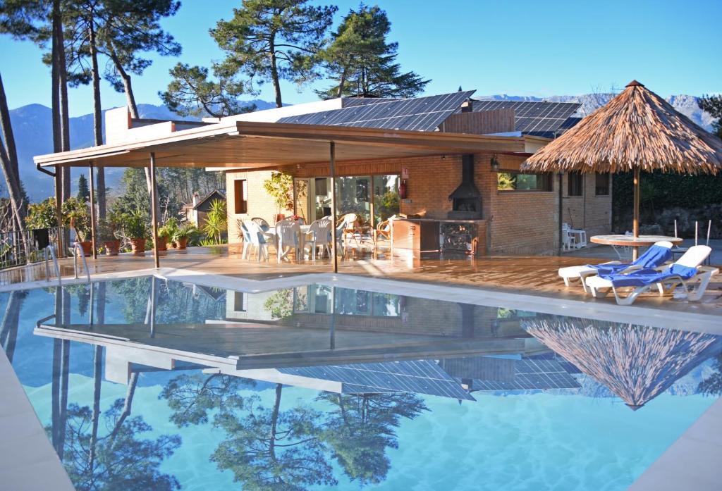 una casa con piscina frente a una casa en AfriKana en Arenas de San Pedro