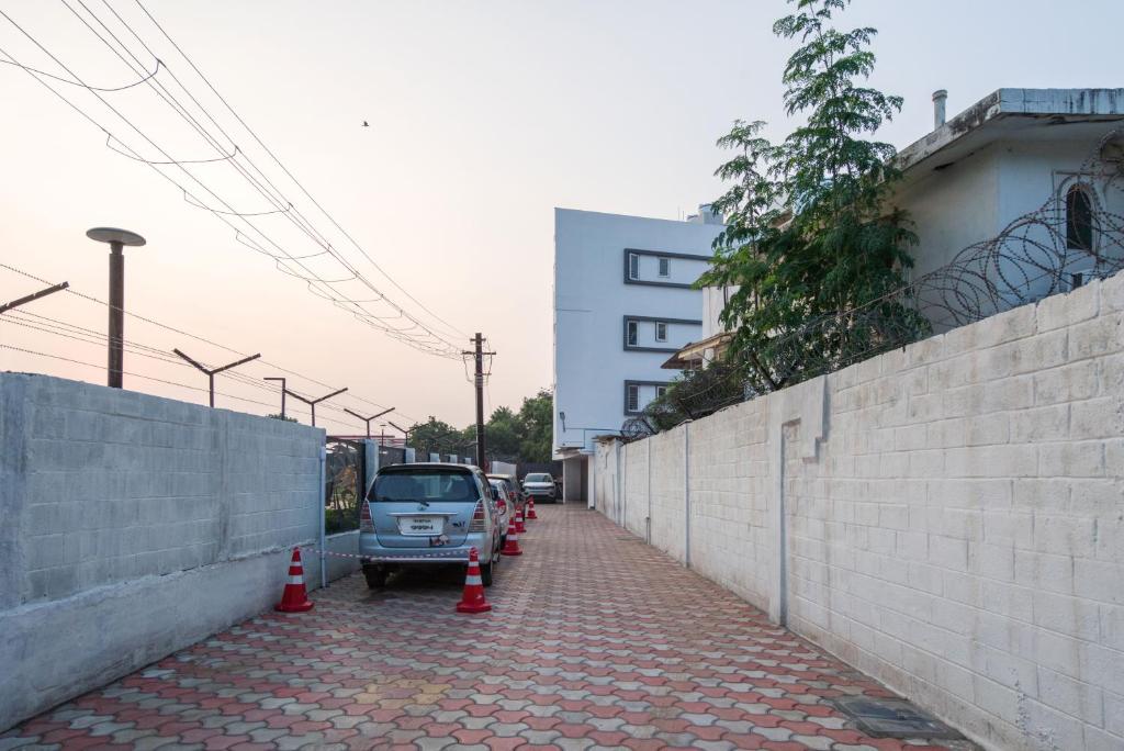 a car parked on a brick sidewalk next to a wall at AAFIYA LAKEVIEW APARTMENTS in Coimbatore