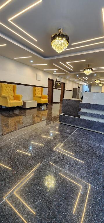 een lobby met gele stoelen en trappen in een gebouw bij Times Square CoLive in Bangalore