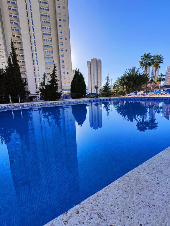 duży niebieski basen przed wysokimi budynkami w obiekcie Playa Levante Lux Mar w mieście Benidorm