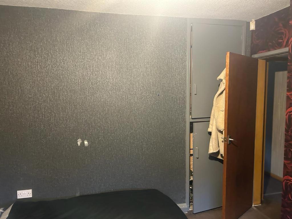 a room with a gray wall and a closet at Heywood in Heywood