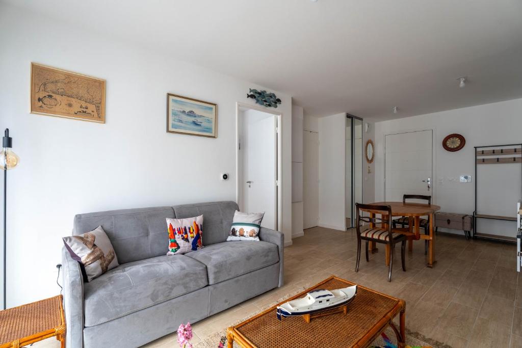 a living room with a couch and a table at CHARMANT APPARTEMENT CENTRE VILLE in Arcachon