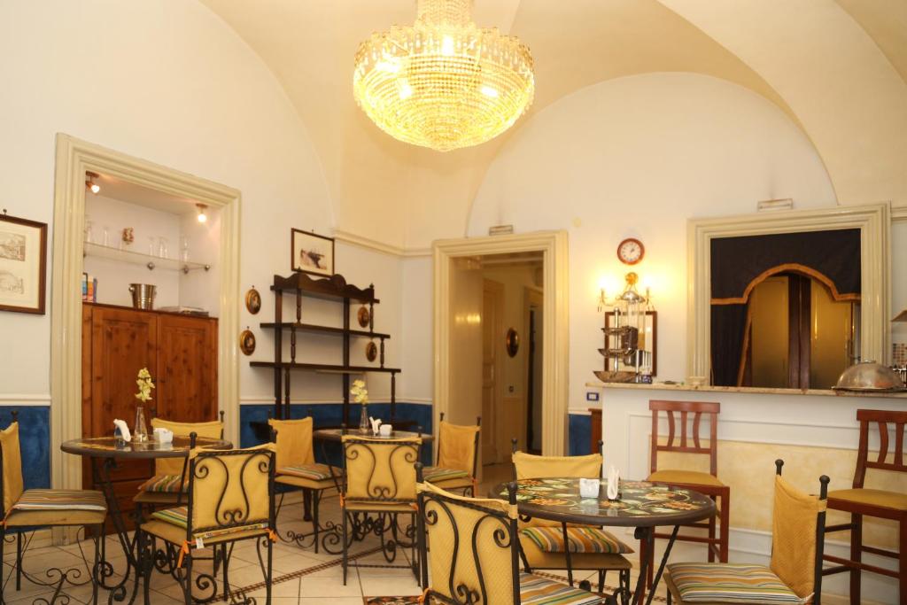 a dining room with tables and chairs and a chandelier at Hotel Sangiuliano 132 centro storico Catania in Catania