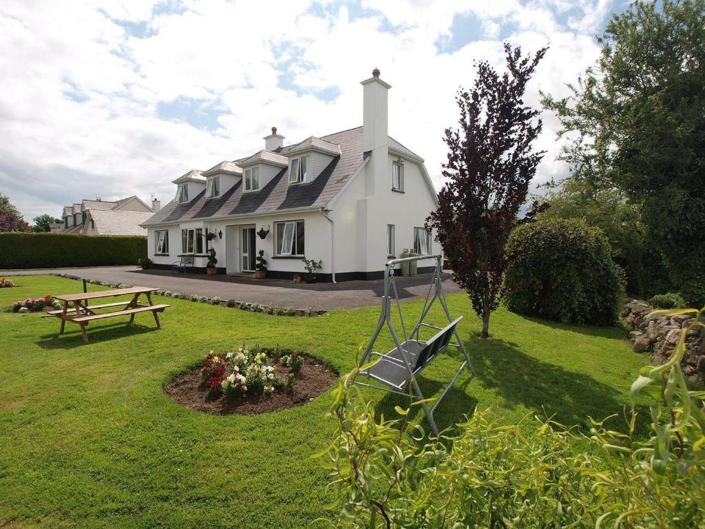 a large white house with a picnic table in the yard at Glencove in Ennis