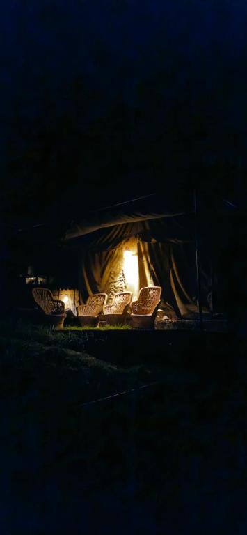 a tent with a lit up fire in the dark at In the jungle camps in Kasol