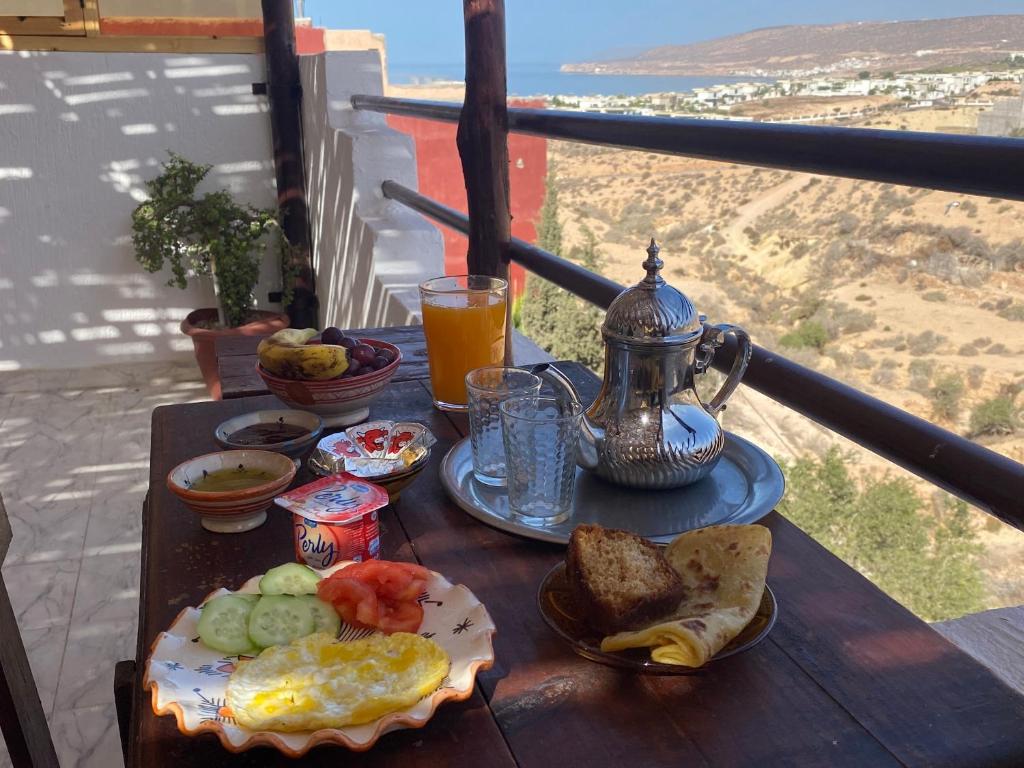 - une table avec petit-déjeuner composé d'œufs et de pain grillé dans l'établissement Red Carpet Surf Camp, à Tamraght Ouzdar