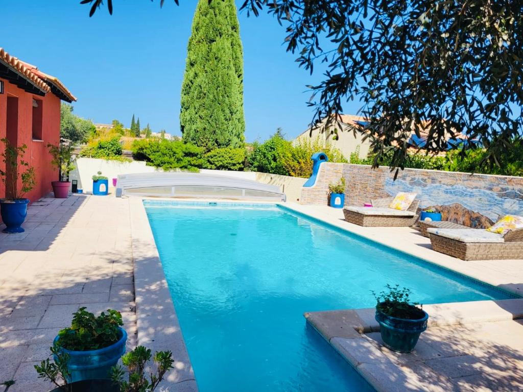 a swimming pool in a yard with a tree at Maison de Celya in Saint-Georges-dʼOrques
