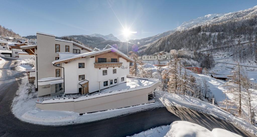 um edifício na neve ao lado de um rio em Aliona Apart em Sölden