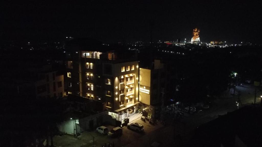 a building with lights on in a city at night at Maruti Group of Hotels - The Shivam in Nāthdwāra