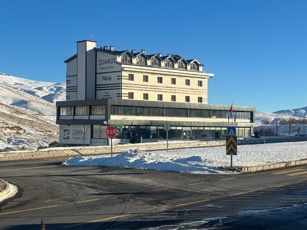 a large building on the side of a road with a stop sign at Zümrüt Palas Otel in Erciyes