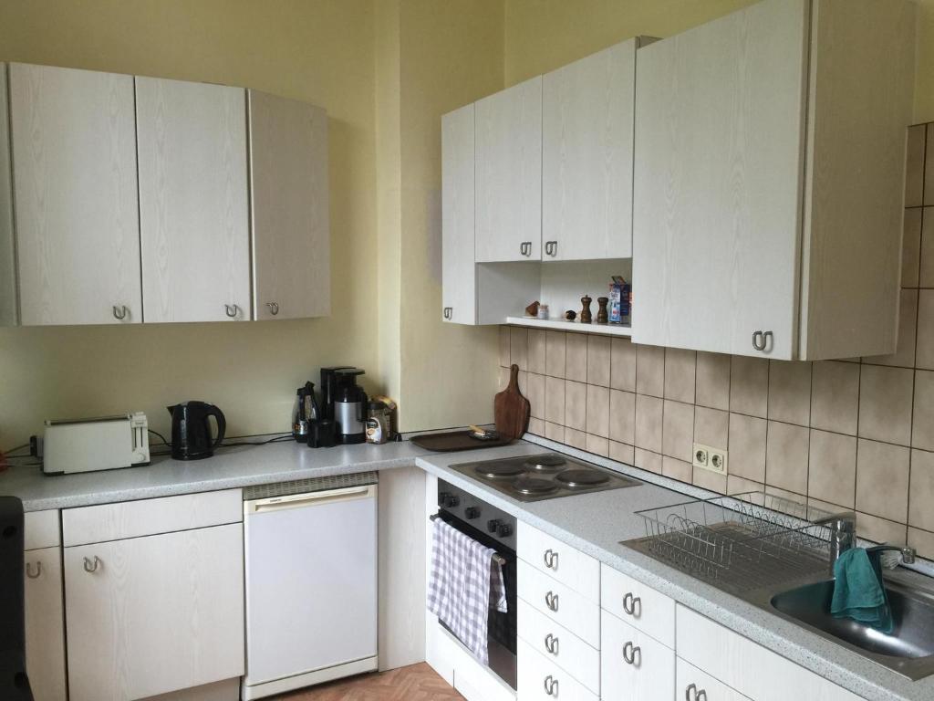 a kitchen with white cabinets and a stove top oven at Schulsportverein Lichtenrade e V in Berlin
