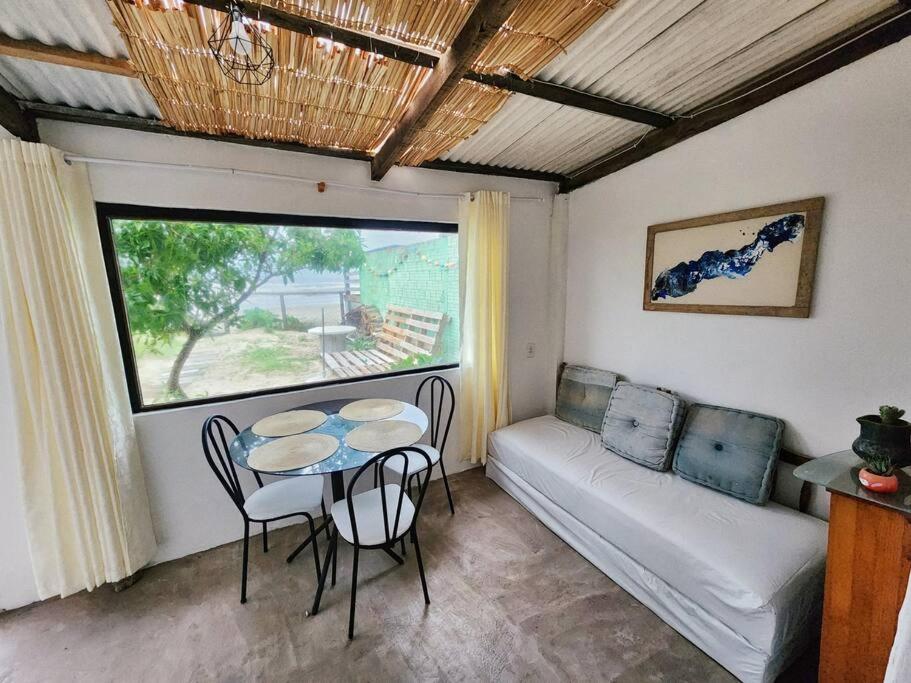 ein Wohnzimmer mit einem Tisch und einem Sofa in der Unterkunft Casa pé na areia in Hermenegildo