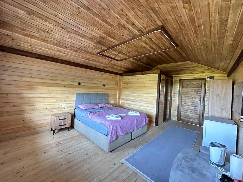 a bedroom with a bed in a wooden cabin at Ağva Bungalov Adult Only in Sile