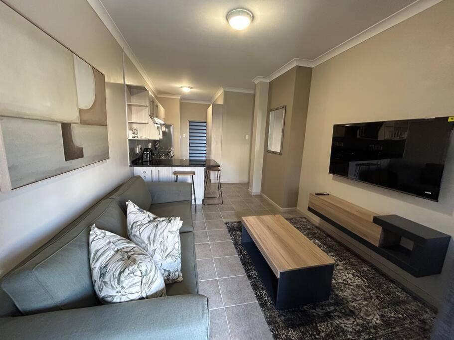 a living room with a couch and a large flat screen tv at Home away from Home in Pretoria