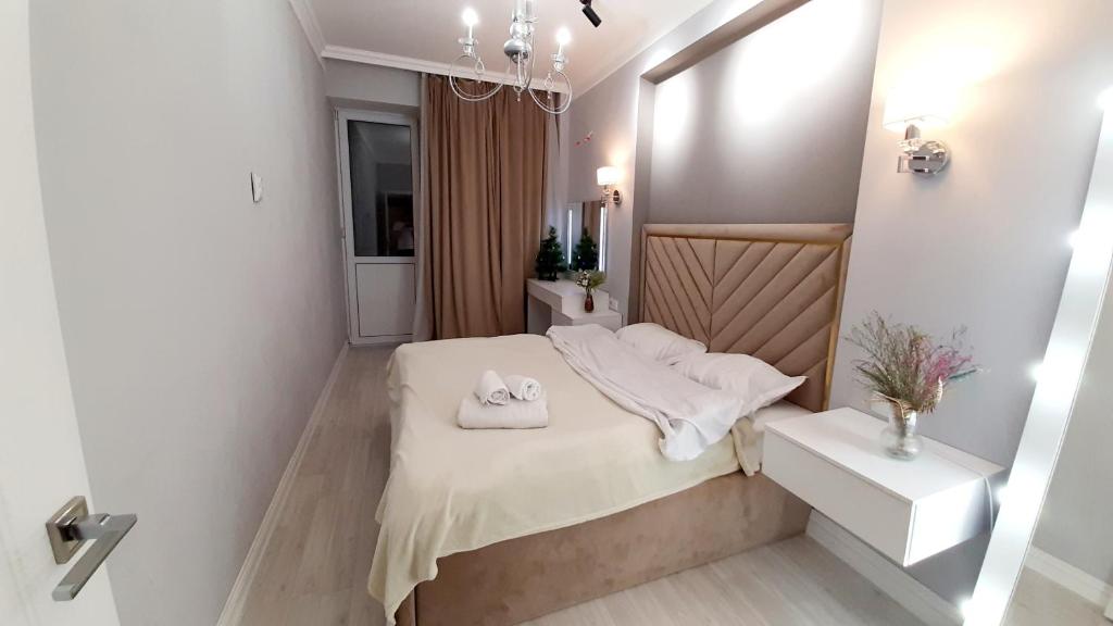 1 dormitorio con 1 cama con 2 toallas en Шолпан сити 2\12, en Almaty