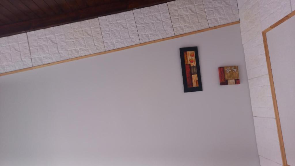 un mur blanc avec deux œuvres d'art sur le mur dans l'établissement Los 3 ases, à Olavarría