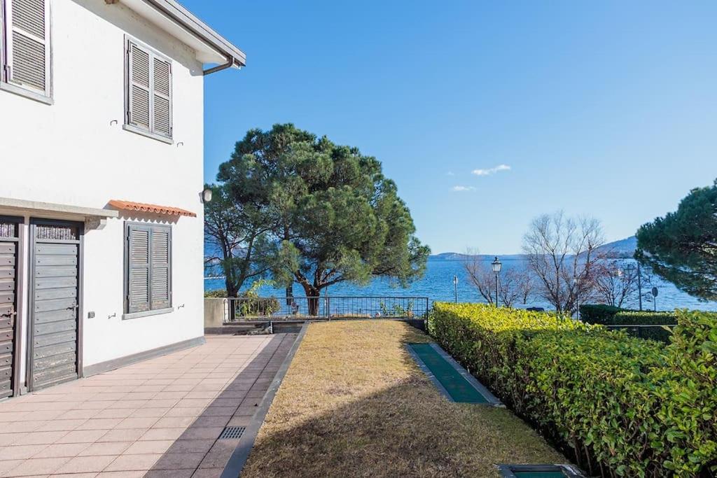 a white house with a view of the water at Lake Maggiore Holiday Apartment in Feriolo