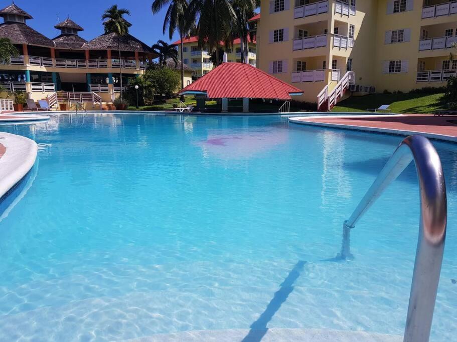 a large blue swimming pool in front of a building at Simply Mystical in Ocho Rios
