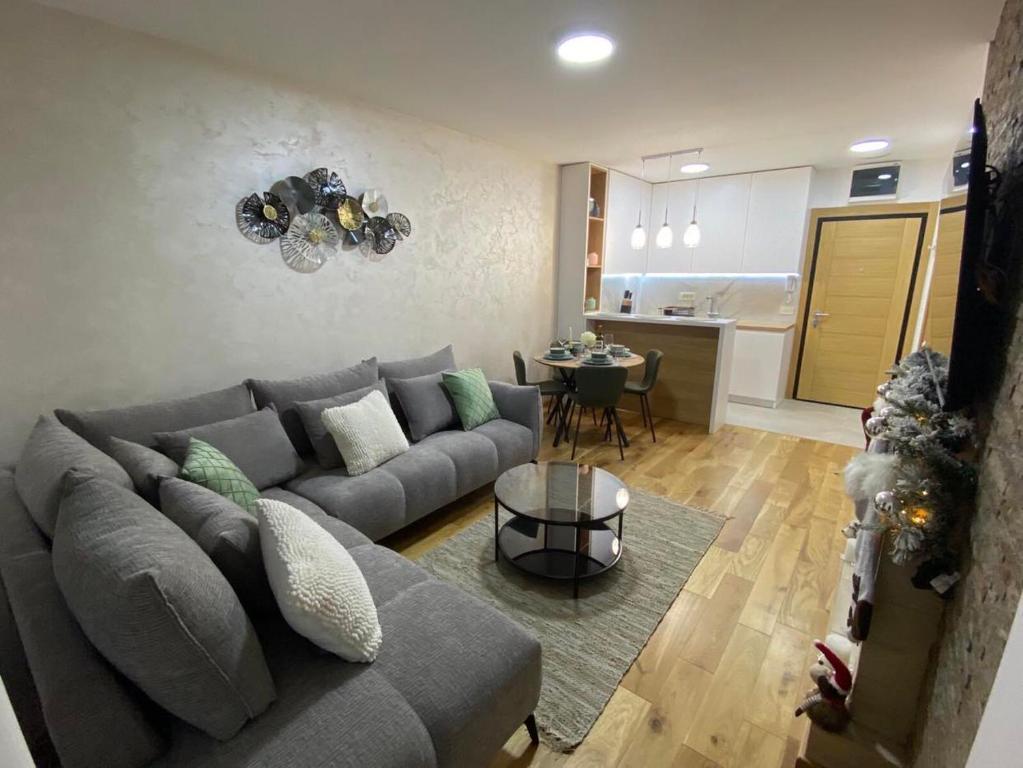 a living room with a gray couch and a table at Apartman ConVista Zlatibor in Zlatibor