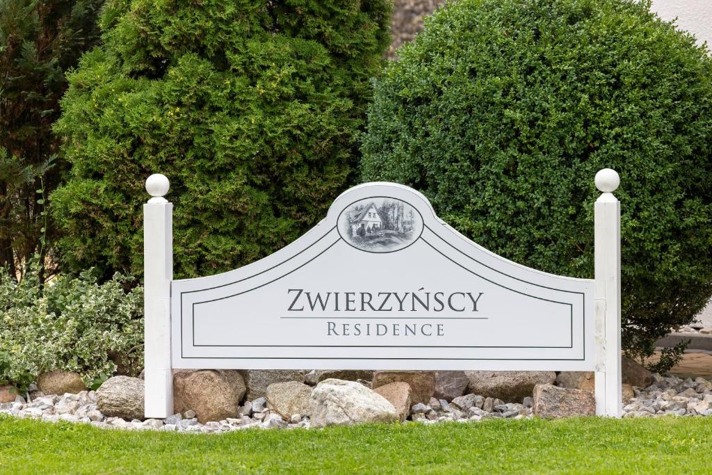 ein Schild für eine Hochschulresidenz in einem Garten in der Unterkunft Zwierzyńscy Residence in Pobierowo