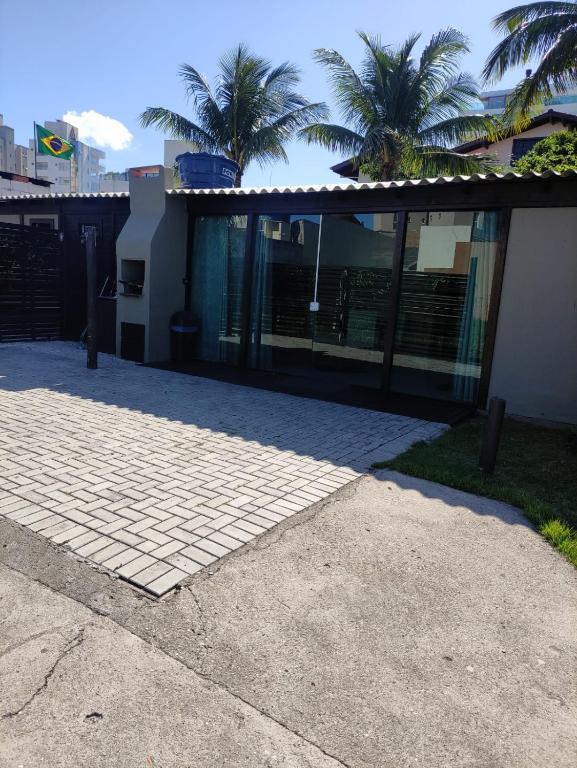 a house with glass doors and palm trees at Casas Bravo in Itajaí