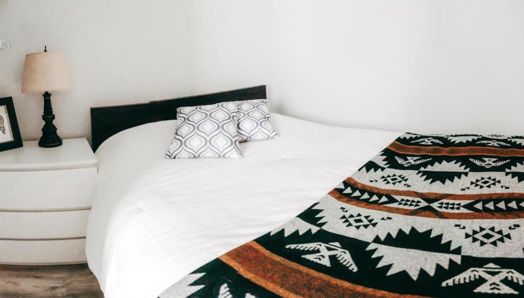 een bed met een zwart-witte deken en kussens bij Small Private Studio at Kitsilano Beach in Vancouver