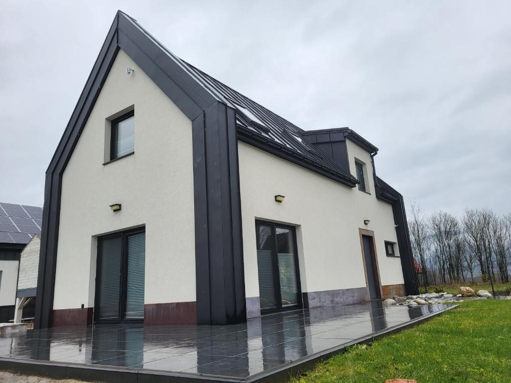 a white house with a black roof at BLACK & WHITE HOUSES in Niedzica