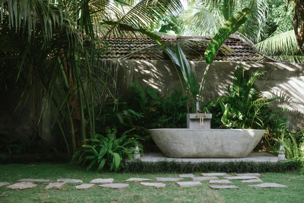 una bañera con una palmera en un jardín en Pantera Lake House, en Ahangama