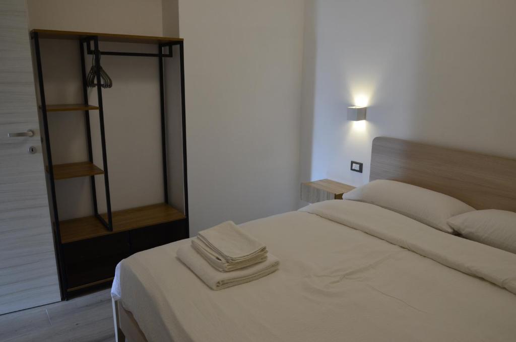 a bedroom with a white bed and a mirror at Manuel Guesthouse Ravascletto in Ravascletto