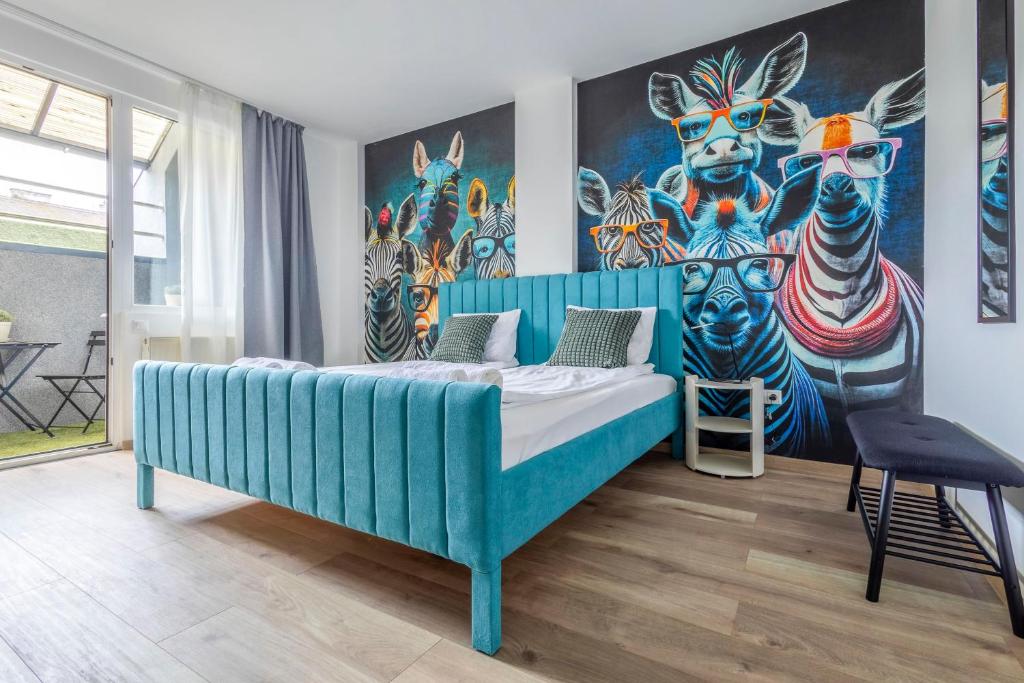 Un dormitorio con una cama azul con una pintura en la pared en Naomi & Sophia Apartman, en Budapest