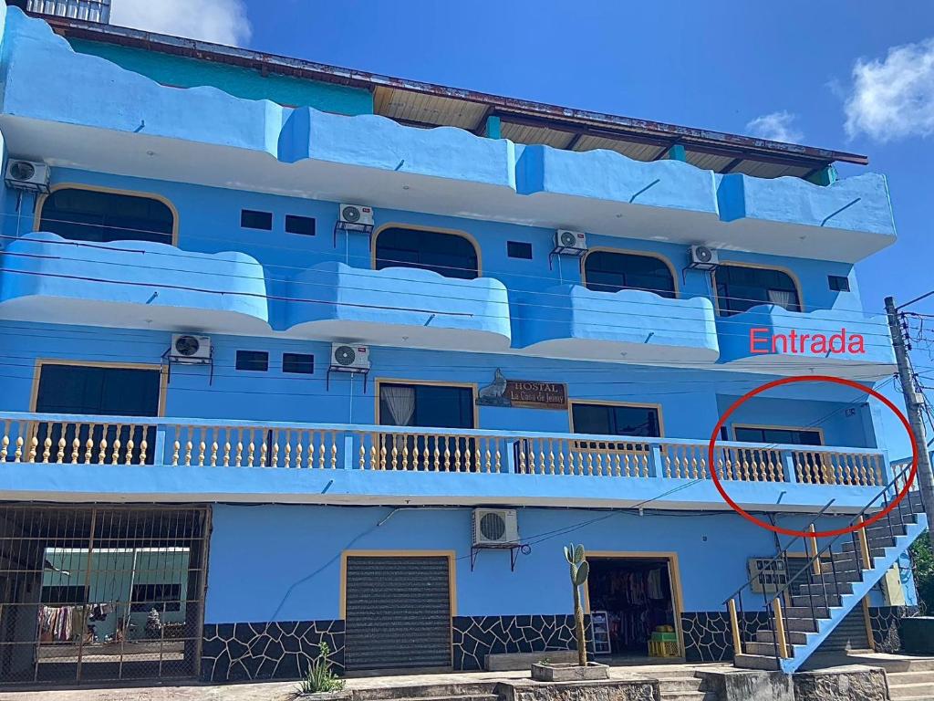 un bâtiment bleu avec les mots emigrada peints sur lui dans l'établissement La Casa de Jeimy, à Puerto Baquerizo Moreno