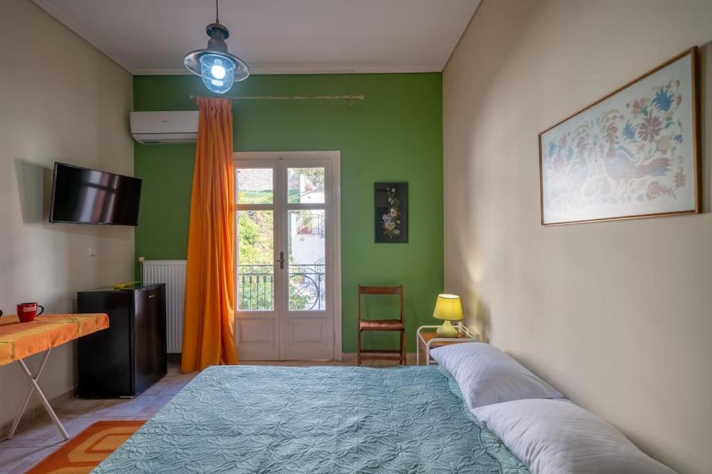 a bedroom with green walls and a large bed at Delphian Colors - Orange Edition in Delphi