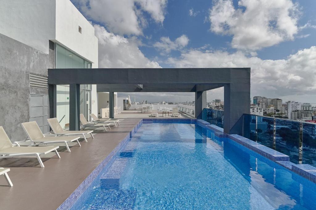 a swimming pool on the roof of a building at Lujoso Apartamento S802 Downtown Santo Domingo in Santo Domingo