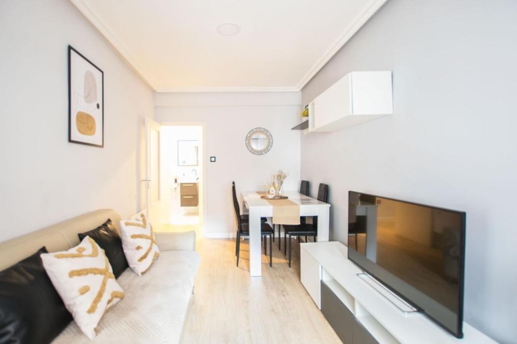 a living room with a couch and a tv and a table at Apartamento moderno y céntrico en Huesca ciudad in Huesca