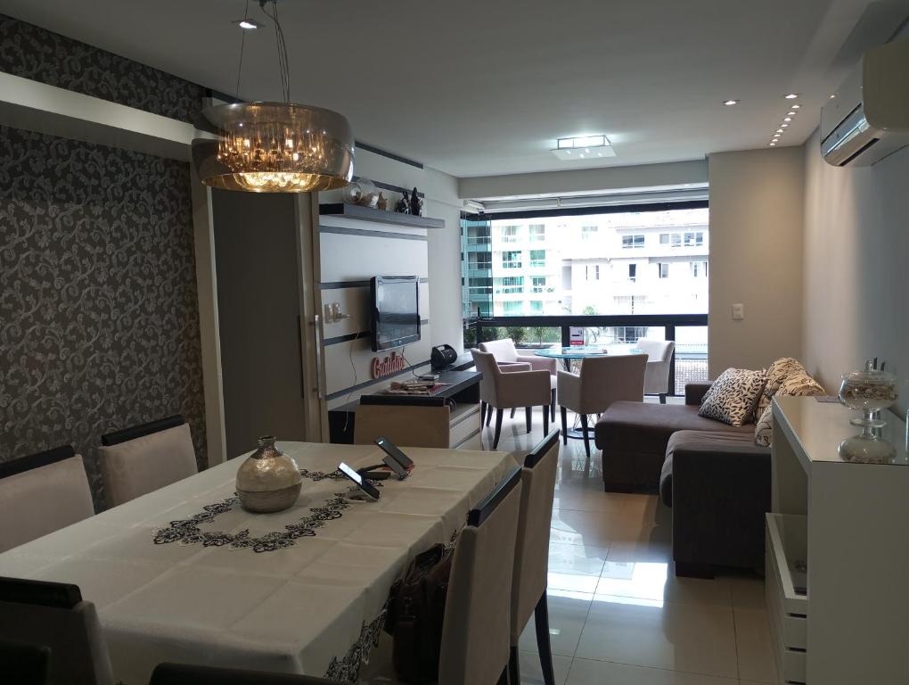 a dining room with a table and a living room at Ótimo Apartamento vista mar a 70 metros in Itapema