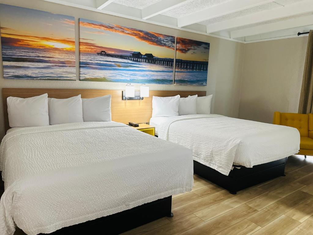 a hotel room with two beds and a painting on the wall at Days Inn by Wyndham Ocala North in Ocala