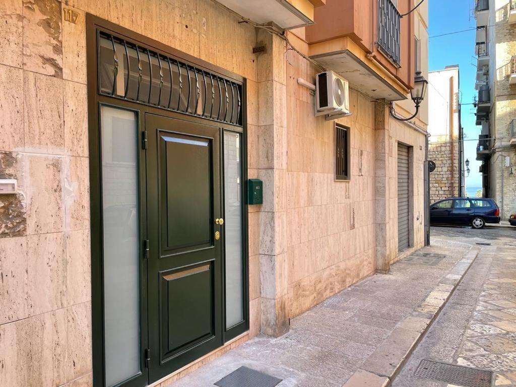 a building with a green door on a street at Appartamento Cosy Centro Storico in Barletta